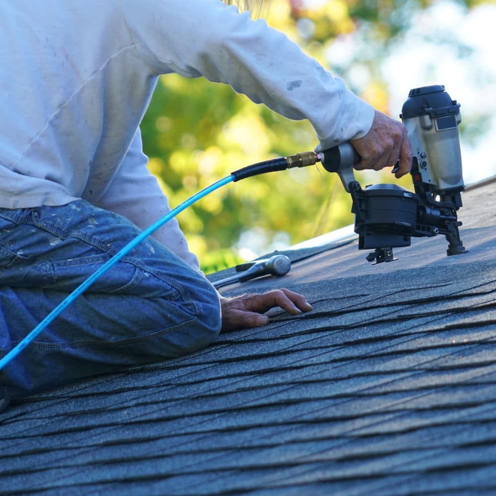 Roofing contractor working on a shingle roof