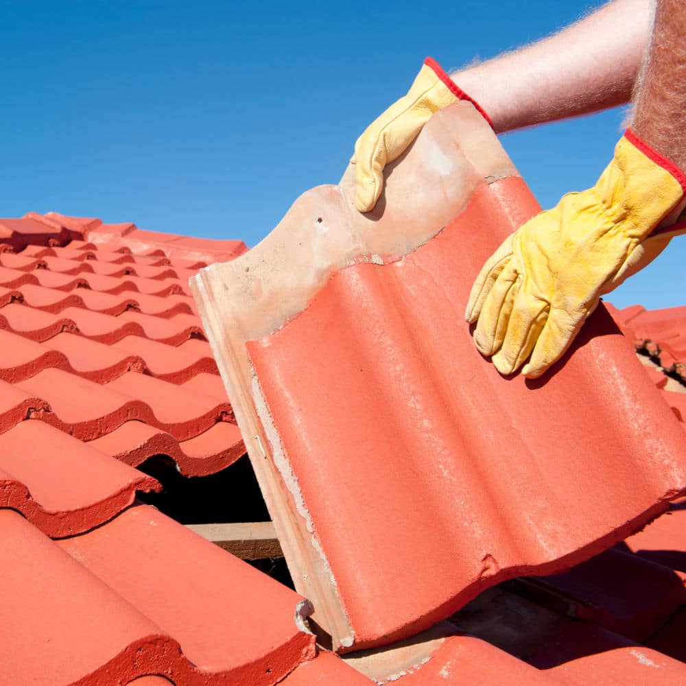 Contractor repairing a tile roof